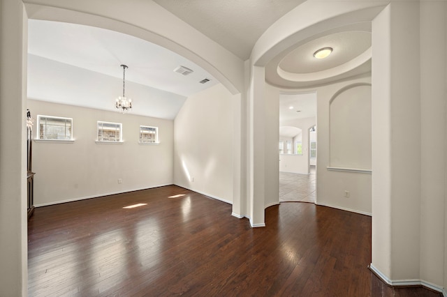 7234 Rambling Tree Ln, Richmond, TX 77407 - spare room with vaulted ceiling, hardwood / wood-style floors, arched walkways, a notable chandelier, and visible vents