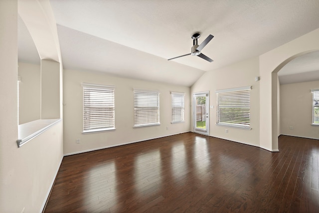 7234 Rambling Tree Ln, Richmond, TX 77407 - unfurnished living room featuring vaulted ceiling, wood finished floors, arched walkways, and ceiling fan