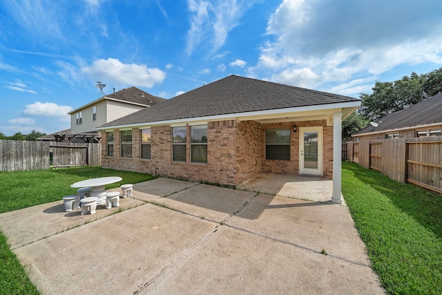 7234 Rambling Tree Ln, Richmond, TX 77407 - back of property with brick siding, a lawn, a fenced backyard, and a patio