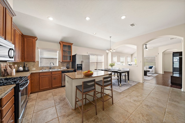 7234 Rambling Tree Ln, Richmond, TX 77407 - kitchen featuring stainless steel appliances, a sink, tasteful backsplash, visible vents, and brown cabinets