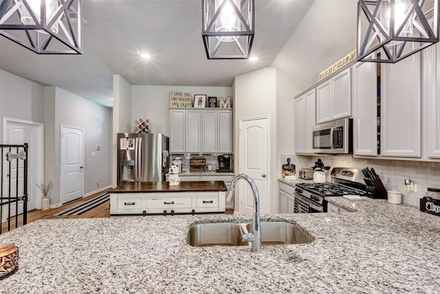 108 Alessandra Way, Huntsville, TX 77320 - kitchen featuring light stone countertops, decorative backsplash, a sink, and appliances with stainless steel finishes