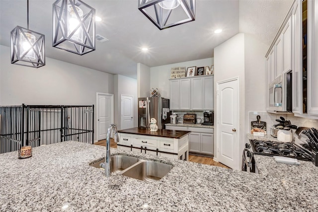 108 Alessandra Way, Huntsville, TX 77320 - kitchen with light stone counters, appliances with stainless steel finishes, decorative backsplash, and a sink