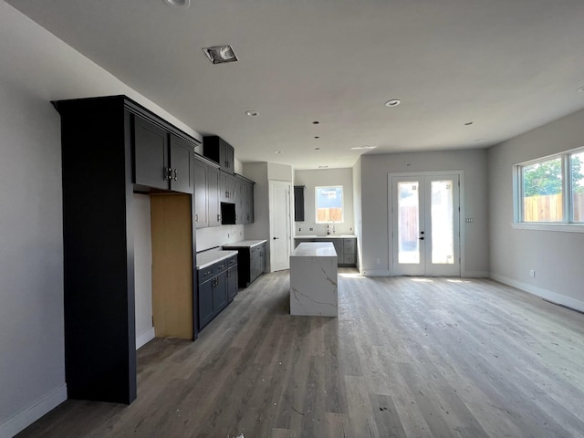6405 Sidney St, Houston, TX 77021 - kitchen with baseboards, a sink, light wood-type flooring, and a kitchen island