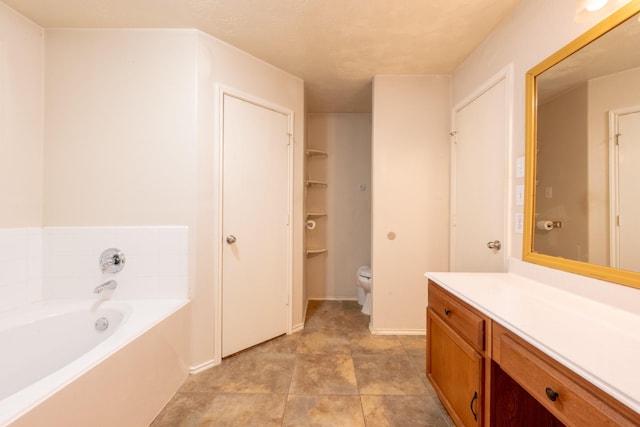 full bathroom with a garden tub, vanity, and toilet