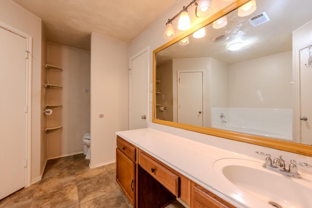 full bath with visible vents, a bathtub, vanity, and toilet