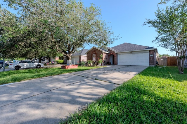 single story home featuring a front lawn, driveway, an attached garage, fence, and brick siding