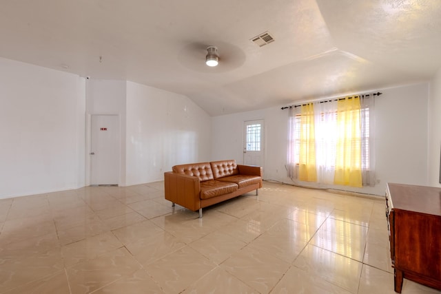 living area featuring vaulted ceiling, a ceiling fan, and visible vents