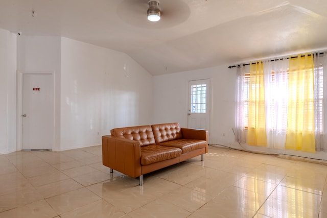 living area featuring light tile patterned floors, vaulted ceiling, and a ceiling fan