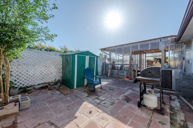 view of patio / terrace featuring a fenced backyard, an outdoor structure, a shed, and grilling area