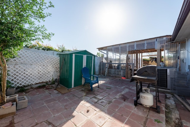 view of patio with a fenced backyard, an outbuilding, and a storage shed