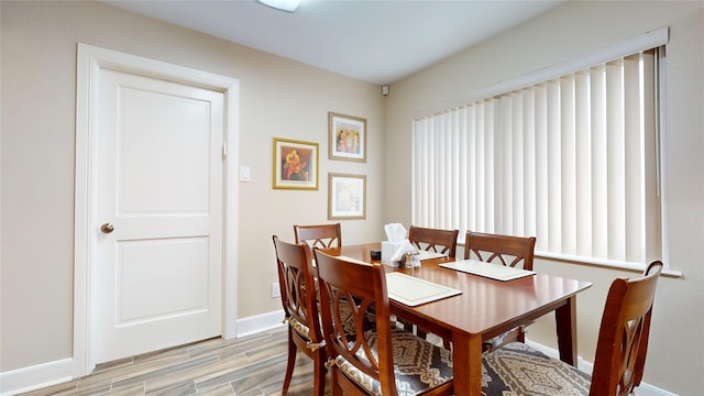 dining space with baseboards and light wood-style floors