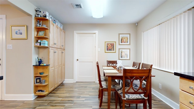 dining area featuring light wood-type flooring, visible vents, and baseboards