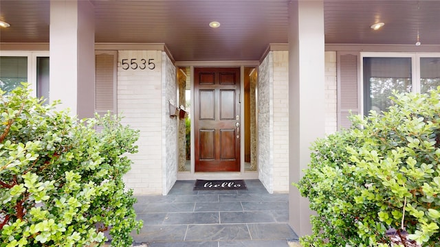 doorway to property featuring brick siding
