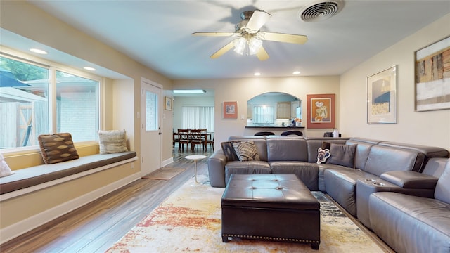 living room with arched walkways, visible vents, recessed lighting, wood finished floors, and ceiling fan