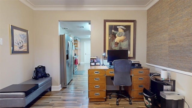 office area with an accent wall, wood finished floors, baseboards, and ornamental molding