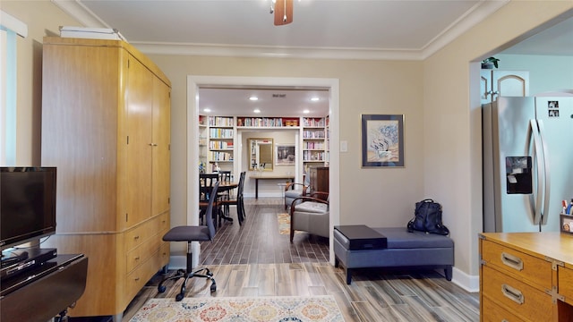 interior space featuring light wood-style flooring, visible vents, crown molding, and baseboards