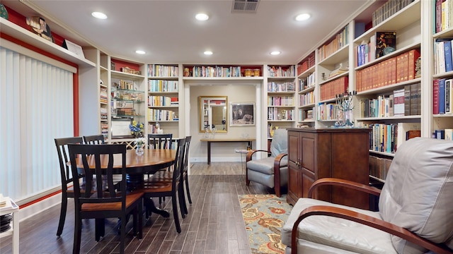 interior space featuring dark wood-style flooring, baseboards, visible vents, recessed lighting, and bookshelves