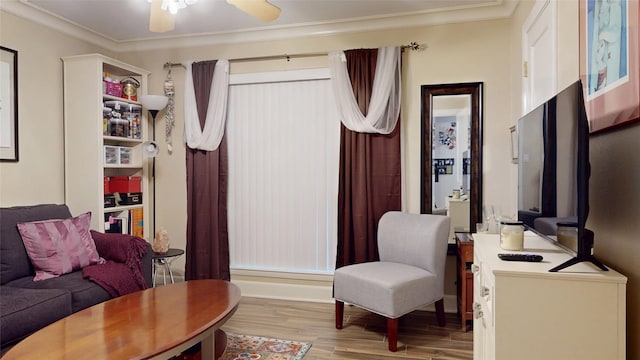 living area featuring ornamental molding, baseboards, a ceiling fan, and wood finished floors