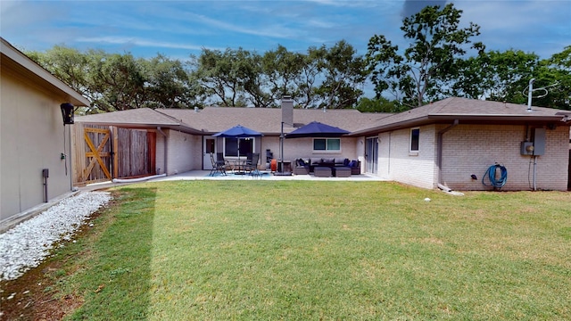 back of property featuring brick siding, outdoor lounge area, a patio area, and a yard