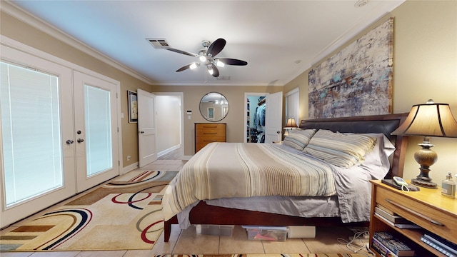 bedroom with a ceiling fan, crown molding, a spacious closet, french doors, and visible vents