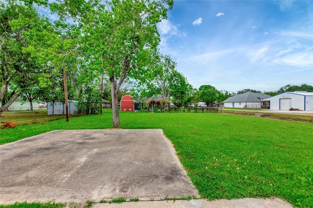 1419 Avenue Ave E, Danbury, TX 77534 - view of yard featuring a detached garage, fence, and an outbuilding
