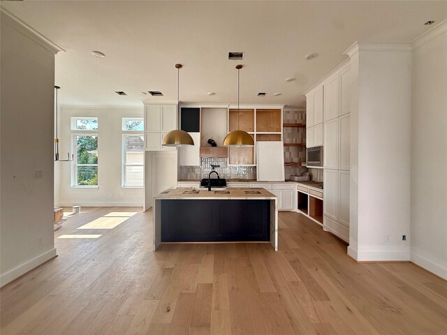 923 Fisher St Unit A, Houston, TX 77018 - kitchen featuring stainless steel microwave, a sink, baseboards, crown molding, and light wood-style flooring