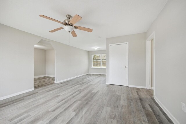 5835 Kenilwood Dr, Houston, TX 77033 - empty room featuring arched walkways, ceiling fan, baseboards, and wood finished floors