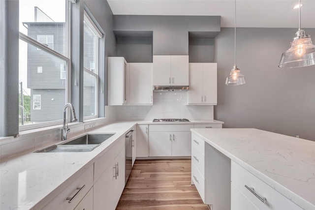 kitchen with white cabinetry, backsplash, appliances with stainless steel finishes, and a sink