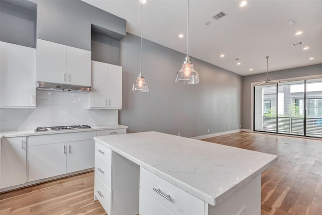 kitchen with light wood finished floors, visible vents, gas stovetop, and under cabinet range hood