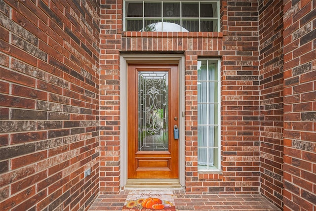 view of exterior entry with brick siding