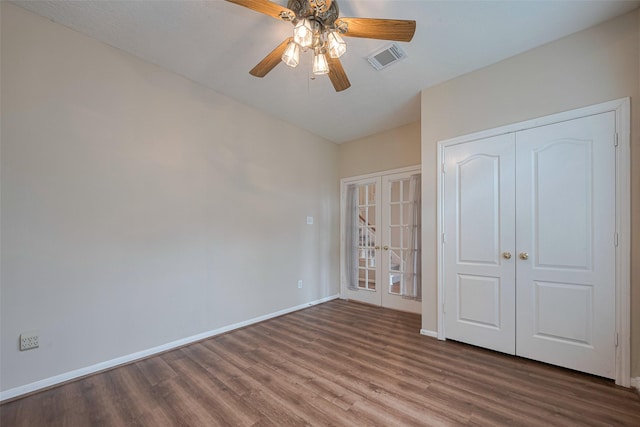 unfurnished bedroom with ceiling fan, french doors, baseboards, wood finished floors, and visible vents