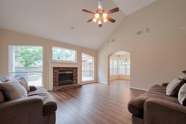 living room featuring visible vents, ceiling fan with notable chandelier, wood finished floors, and high vaulted ceiling