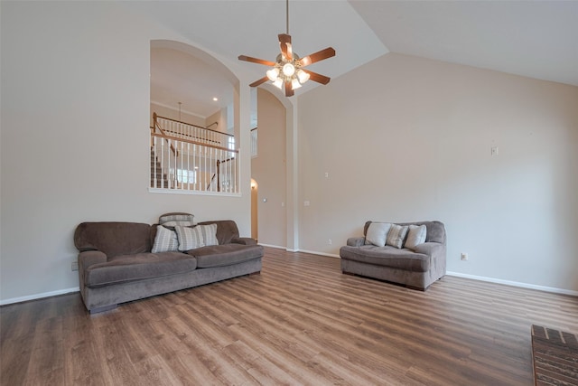living area featuring high vaulted ceiling, a ceiling fan, arched walkways, and wood finished floors