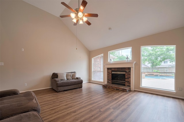 living room featuring wood finished floors, a fireplace, baseboards, high vaulted ceiling, and a ceiling fan