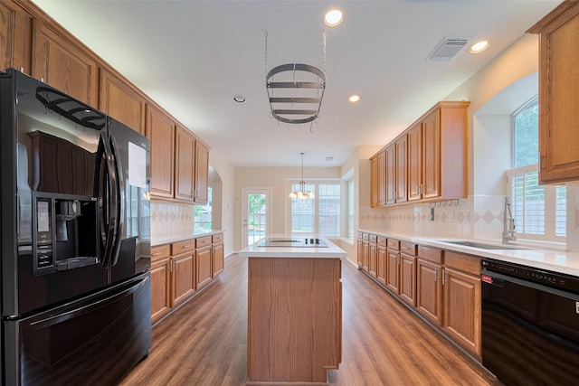 kitchen with visible vents, a center island, recessed lighting, black appliances, and a notable chandelier