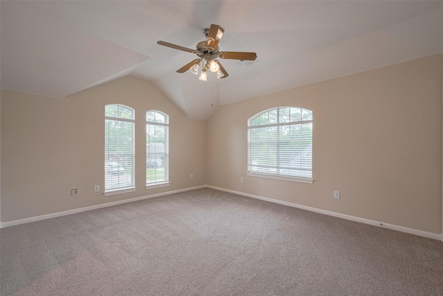carpeted empty room with baseboards, ceiling fan, and vaulted ceiling