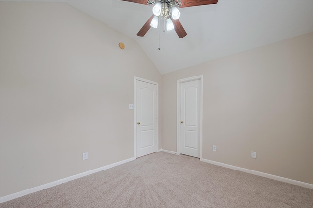 spare room featuring baseboards, a ceiling fan, vaulted ceiling, and light carpet