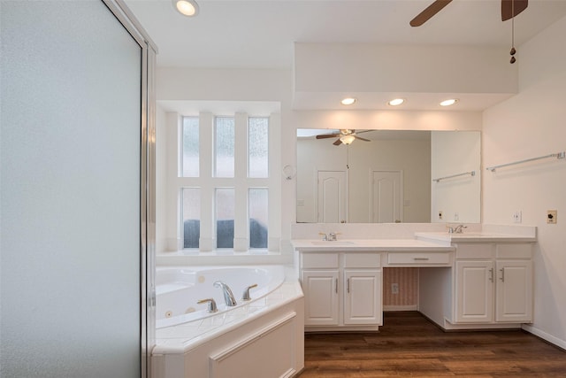 bathroom with a sink, a whirlpool tub, a ceiling fan, and wood finished floors