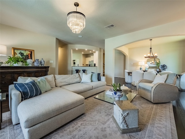 2560 Wild Oak Forest Ln, Seabrook, TX 77586 - living room featuring arched walkways, a chandelier, visible vents, and wood finished floors
