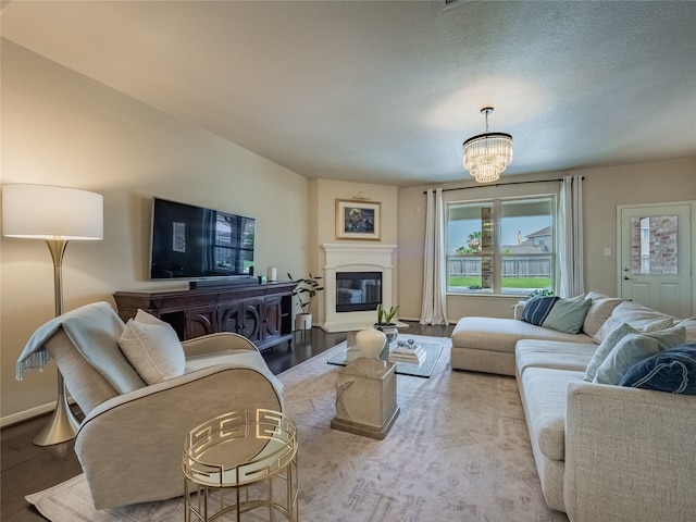 2560 Wild Oak Forest Ln, Seabrook, TX 77586 - living room with a glass covered fireplace, a chandelier, plenty of natural light, and wood finished floors