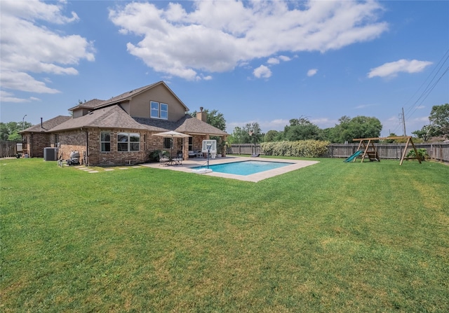2560 Wild Oak Forest Ln, Seabrook, TX 77586 - back of property featuring a chimney, central AC, a patio area, a playground, and a fenced backyard
