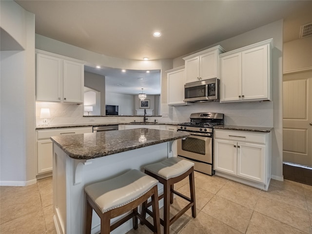2560 Wild Oak Forest Ln, Seabrook, TX 77586 - kitchen featuring a sink, stainless steel appliances, a kitchen breakfast bar, backsplash, and white cabinets
