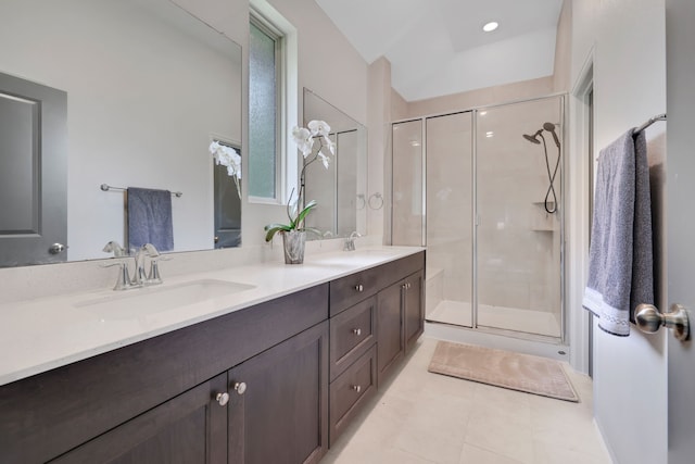 full bathroom with a sink, tile patterned flooring, a stall shower, and double vanity