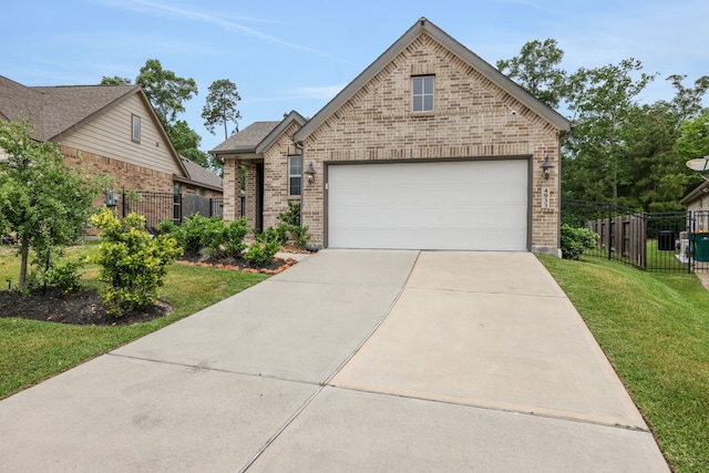 view of front of house with brick siding, fence, driveway, and a front yard