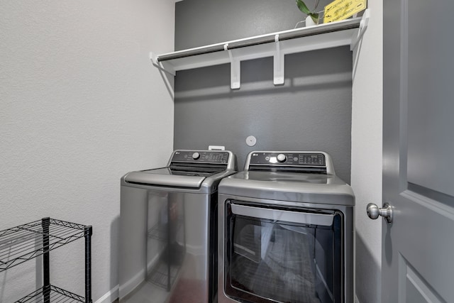 washroom featuring a textured wall, laundry area, and independent washer and dryer