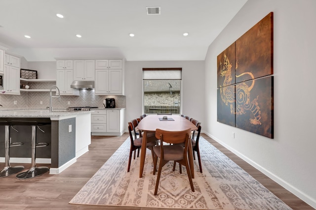 dining space featuring baseboards, visible vents, and light wood-style floors