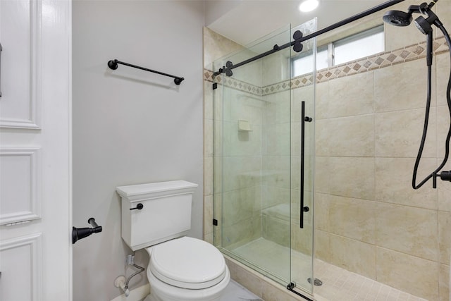 bathroom featuring baseboards, toilet, and a stall shower