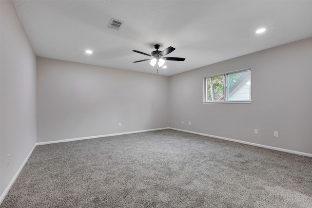 unfurnished room with carpet floors, visible vents, a ceiling fan, and baseboards