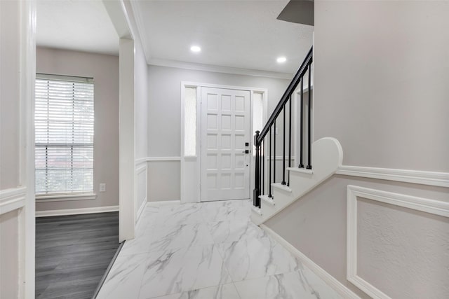 foyer with stairs, a healthy amount of sunlight, crown molding, and baseboards