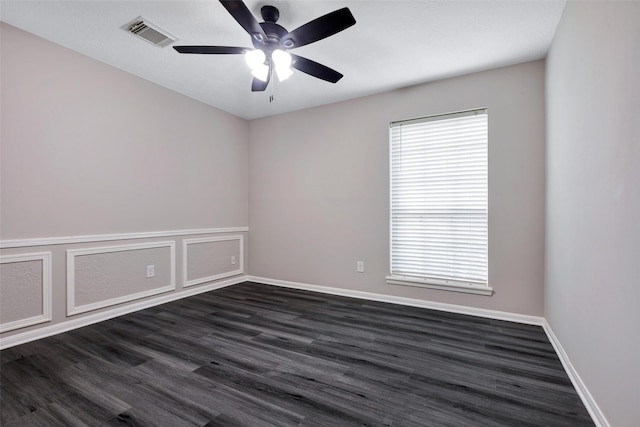 unfurnished room featuring ceiling fan, visible vents, baseboards, and dark wood-style flooring